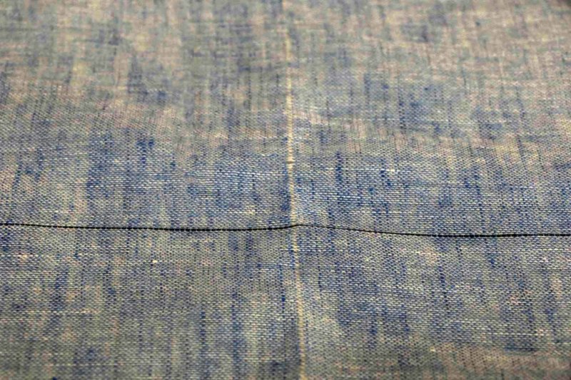 縦の白い筋が糸を抜いた跡。クロスする黒い線は、糸を抜く前。ショールの横幅に合わせてそこだけ違う色糸を織り込み目印にしてある