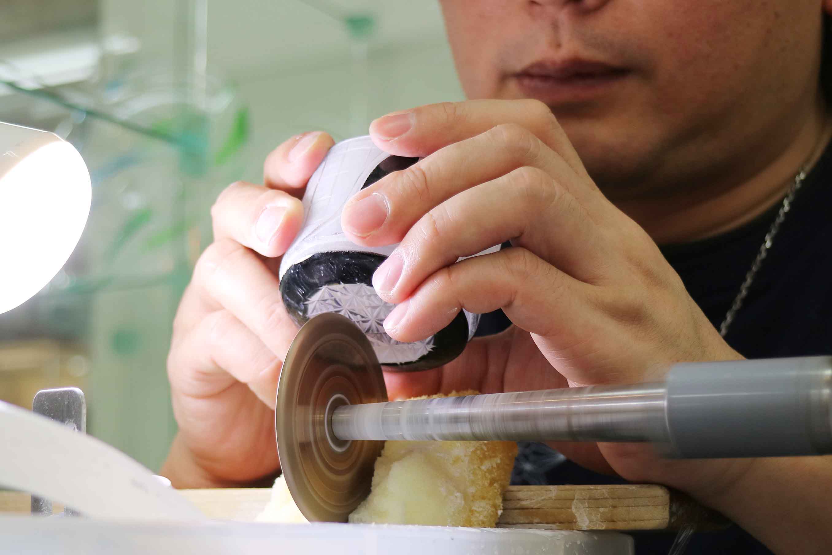 江戸切子は研磨機を使って、回転するダイヤモンドホイールにガラスを当て、削り出していきます